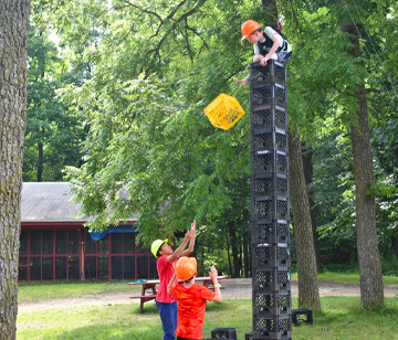 Crate stacking is an extremely fun activity, which tests campers' balance and coordination, while also requiring teamwork. The object of the activity is to construct a tower of crates while balancing and climbing. Campers enjoy the challenge and self-esteem building experience that comes with trying to climb as high as possible. Our experienced instructors talk you through every step with extreme safety in mind.
