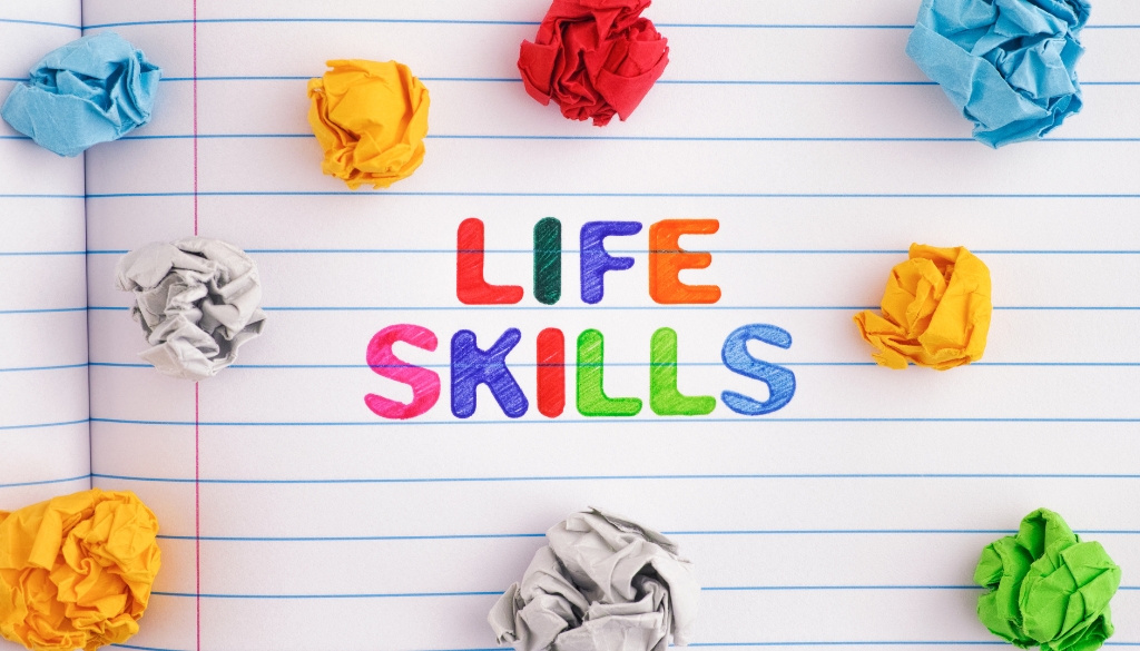 Life Skills in colorful writing in a notebook with colorful balls of paper.