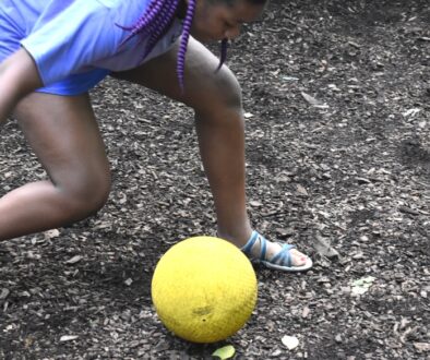 A black girl camper from Camp Kupugani hitting the GaGa ball in mid play.