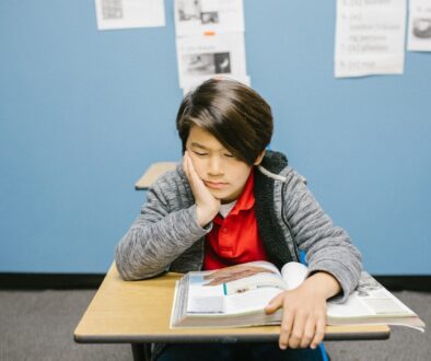 An Asian kid displaying low self-esteem in a classroom.