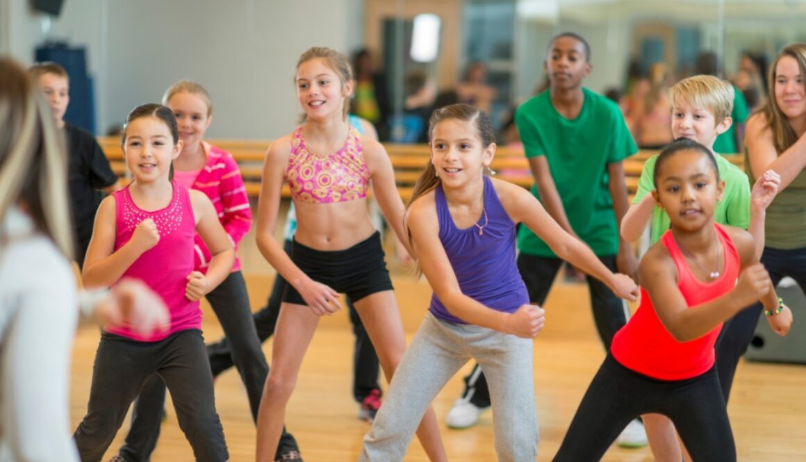 A group of kids at a dance class perfecting their dance routine.