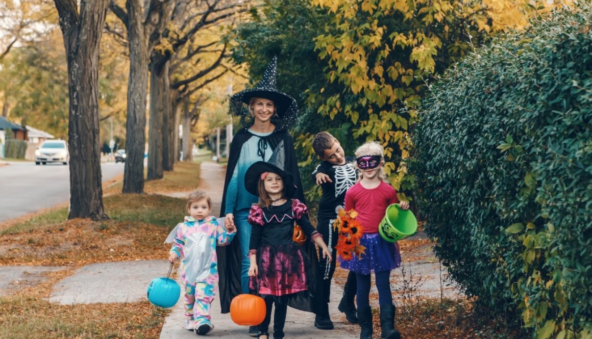 Family dressed in halloween costumes goes trick-or-treating. Camp Kupugani tips for an eco-friendly and socially responsible Halloween.