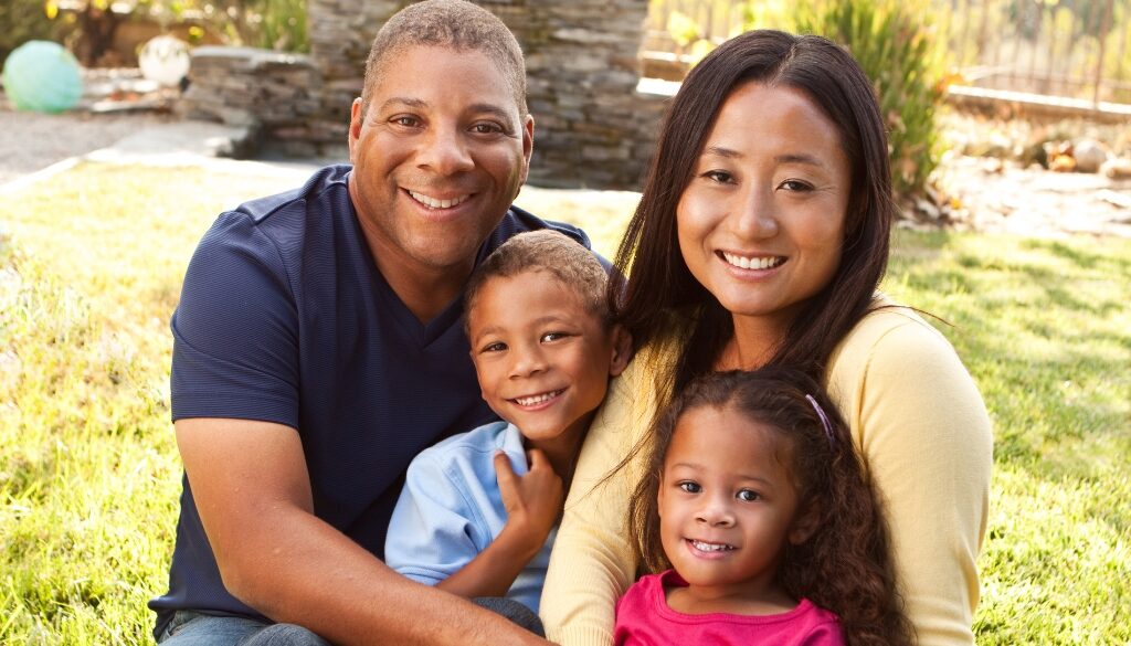 Multicultural parenting tips from Camp Kupugani. A multicultural family smiles.